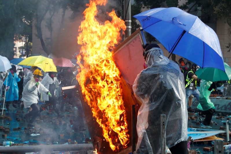 Un manifestante mueve una barricada en llamas en Hong Kong