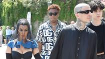 <p>give off goth bride and groom vibes in their coordinating Dolce & Gabbana looks <a href="https://people.com/tv/kourtney-kardashian-and-travis-barker-spotted-in-all-black-ensembles-ahead-of-wedding/" rel="nofollow noopener" target="_blank" data-ylk="slk:at their pre-wedding lunch on Saturday;elm:context_link;itc:0;sec:content-canvas" class="link ">at their pre-wedding lunch on Saturday</a>: the bride in a black mini dress with a fitted bustier and an emblem of religious iconography appearing to be of the Madonna in the center, plus <a href="https://twitter.com/planetKourt/status/1527996306450440193" rel="nofollow noopener" target="_blank" data-ylk="slk:black veil with blue lace trim;elm:context_link;itc:0;sec:content-canvas" class="link ">black veil with blue lace trim</a>, long black gloves and dark eye makeup, and Barker matching in a long-sleeve black robe-like look, black sunglasses, chunky black shoes and a chainlink necklace.</p>