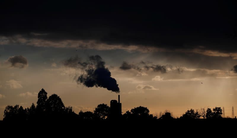 Smoke rises above a factory at sunset in Rugby