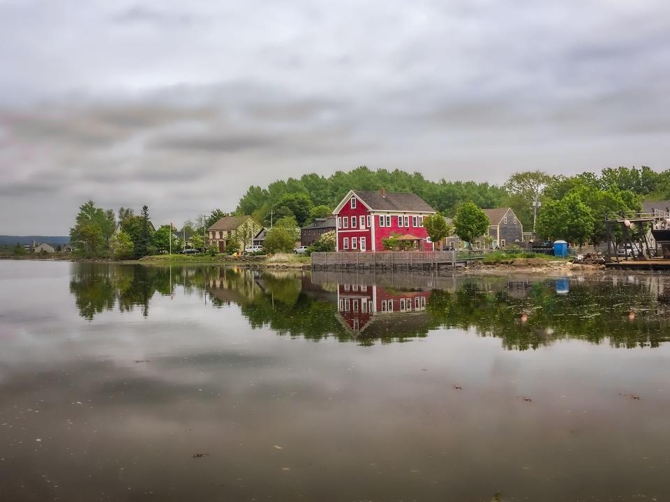 Houses reflecting on a lake with a gray sky in Maryland.