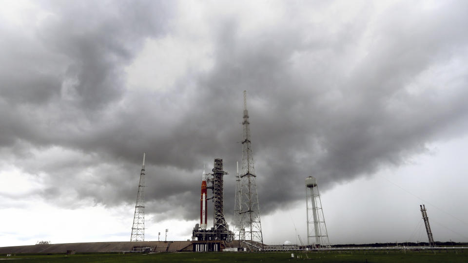 Storm clouds roll in over the NASA moon rocket as it stands ready for launch on Pad 39B for the Artemis 1 mission at the Kennedy Space Center, Saturday, Aug. 27, 2022, in Cape Canaveral, Fla. The launch is scheduled for Monday morning Aug. 29. (AP Photo/John Raoux)