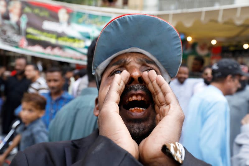 FILE PHOTO: A supporter of a political party chants slogans with others outside a polling station during voting to elect lawmakers for legislative assembly in Pakistan-administered Kashmir, in Karachi