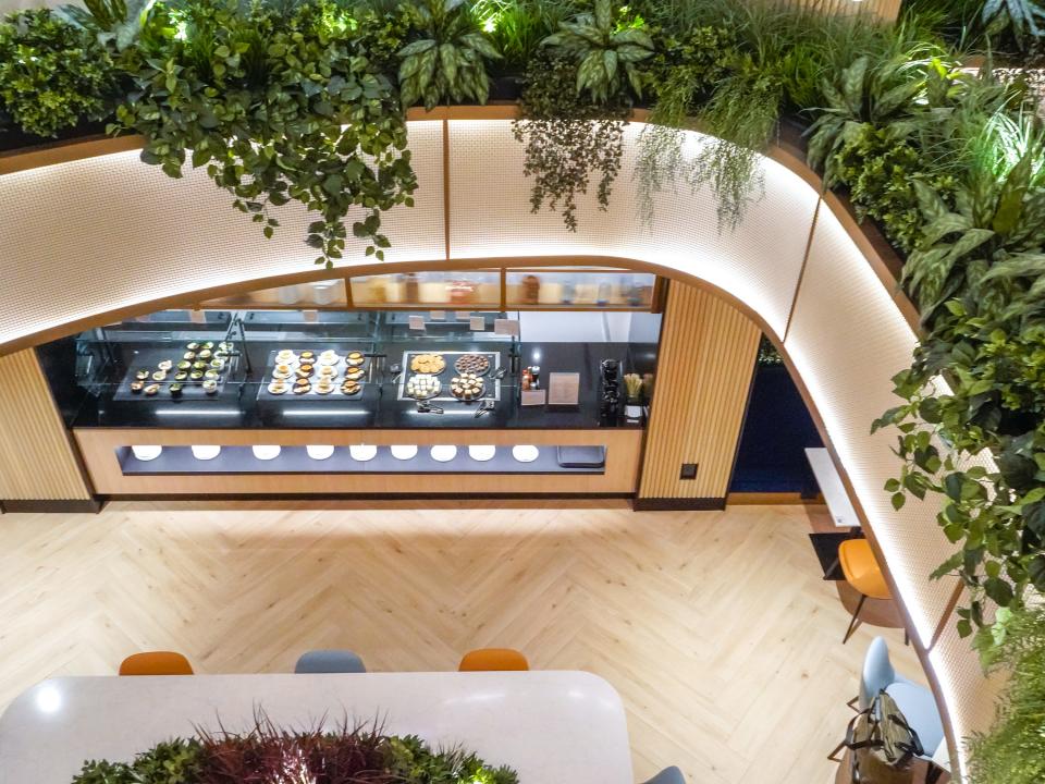 An aerial view of a buffet and dining area with plants hanging over the mezzanine