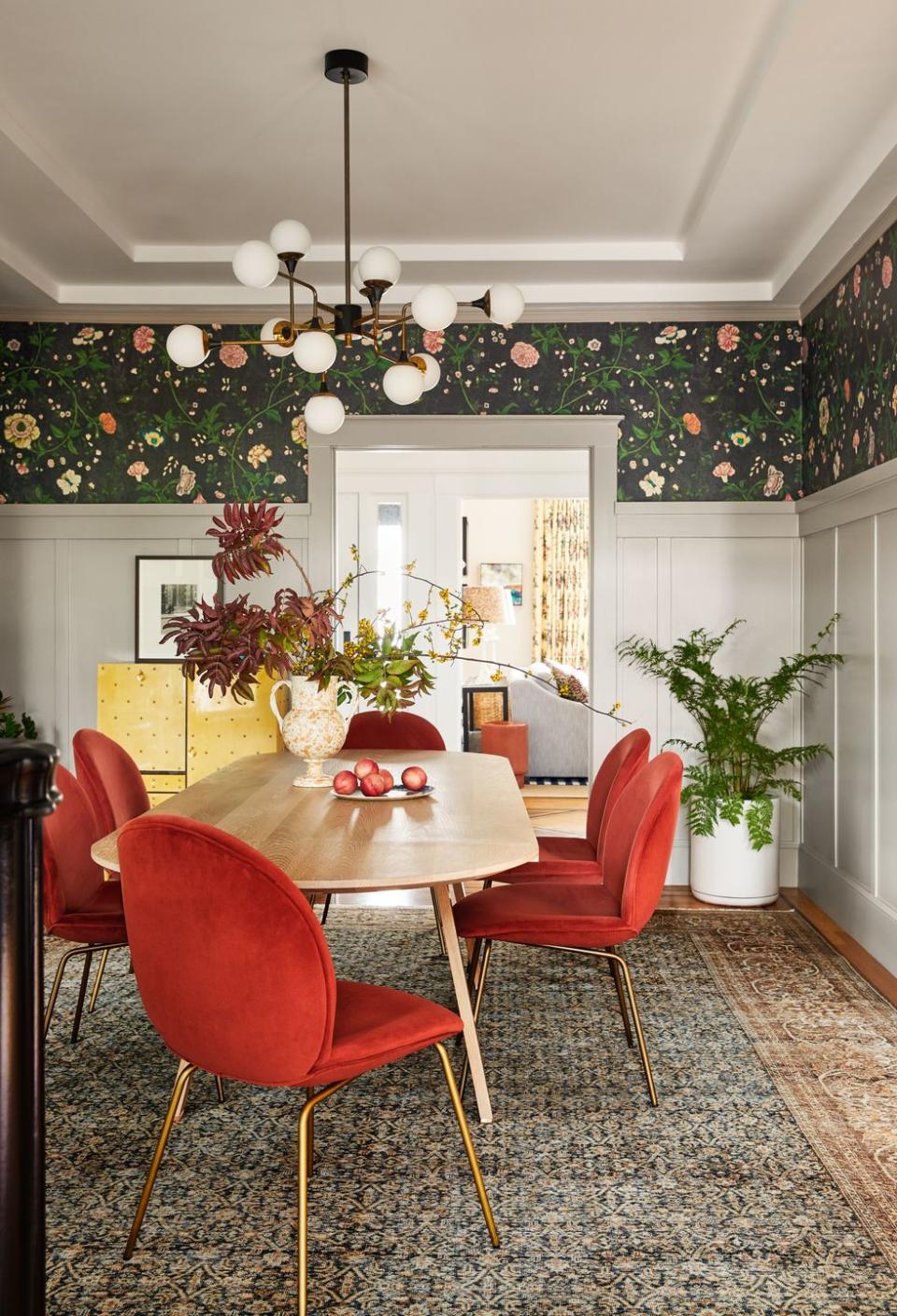 an oblong dining table with red chairs