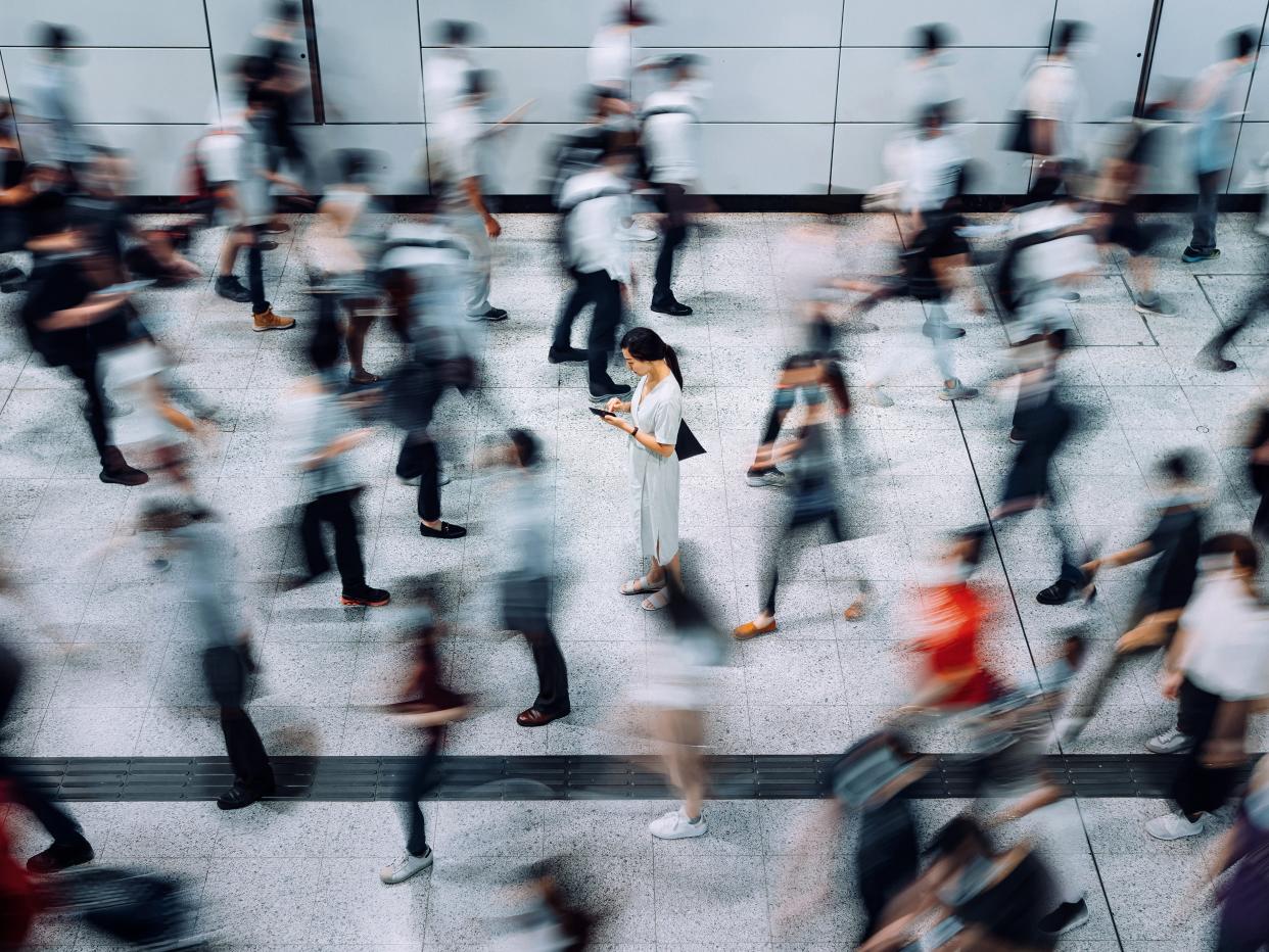 A woman in a busy subway station.