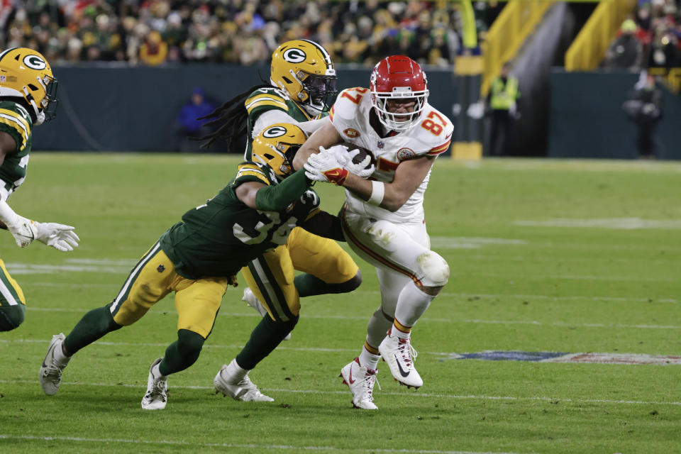 Kansas City Chiefs tight end Travis Kelce (87) runs after a catch as Green Bay Packers safety Jonathan Owens (34) reaches for the ball during the first half of an NFL football game Sunday, Dec. 3, 2023 in Green Bay, Wis. (AP Photo/Mike Roemer)