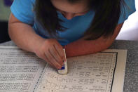 Lily Osgood, 7, corrects a math problem while studying at her family's home, Tuesday, July 20, 2021, in Fairfax, Vt. Lily and her brother, Noah, 12, will continue to be homeschool this upcoming school year. For some families, the switch to homeschooling was influenced by their children’s special needs. Having observed Lily’s progress with reading and arithmetic while at home during the pandemic, her mother, Jennifer, is convinced homeschooling is the best option for her going forward. (AP Photo/Charles Krupa)