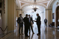 Congressional staffers wait in the ornate corridor outside the Senate chamber during a delay in work on the Democrats' $1.9 trillion COVID-19 relief bill, at the Capitol in Washington, Friday, March 5, 2021. (AP Photo/J. Scott Applewhite)