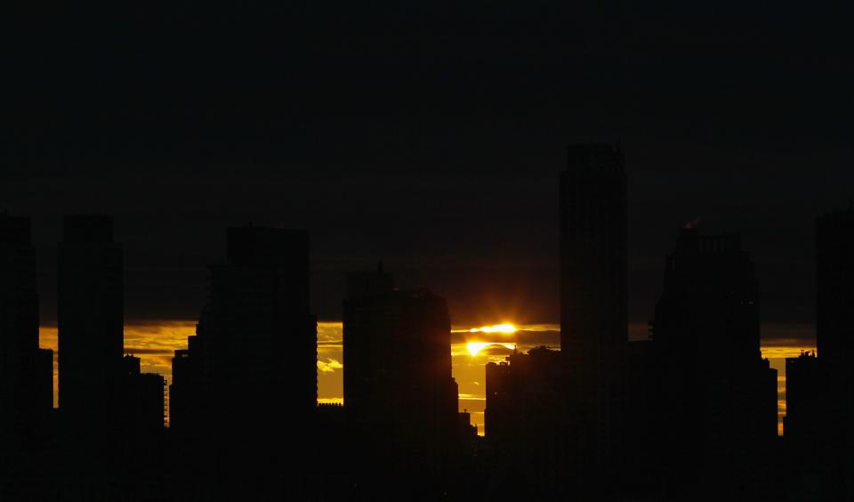 The sun rises behind the skyline of Manhattan as it is partially eclipsed by the moon during a hybrid eclipse over New York, November 3, 2013. REUTERS/Gary Hershorn (UNITED STATES - Tags: ENVIRONMENT CITYSCAPE TPX IMAGES OF THE DAY)