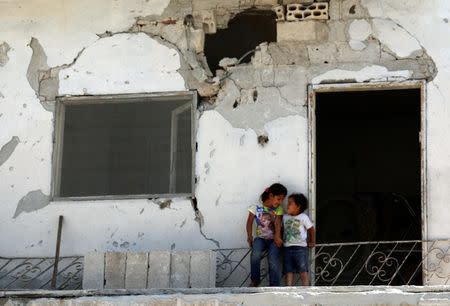 Children are seen at a damaged house in the rebel-held area in Deraa, Syria July 26, 2017. REUTERS/Alaa al-Faqir