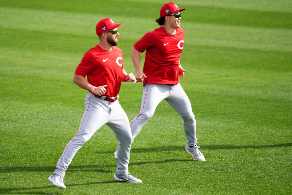 Cincinnati Reds right fielder Nick Martini (23) and Cincinnati Reds left fielder Stuart Fairchild (17) participate in warm ups during spring training workouts, Friday, Feb. 23, 2024, at the team’s spring training facility in Goodyear, Ariz.