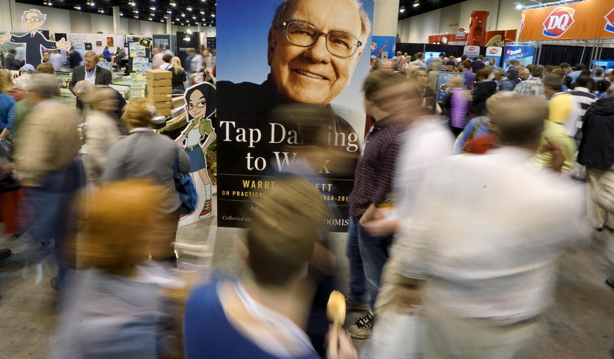 Berkshire Hathaway shareholders walk around the exhibits with a photo of Berkshire CEO Warren Buffett in the center at the Berkshire annual meeting in Omaha, Nebraska May 2, 2015.  REUTERS/Rick Wilking