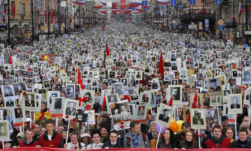 Local residents carry portraits of their ancestors, participants in World War Two as they celebrate Victory Day in St.Petersburg, Russia, Friday, May 9, 2014. About 30,000 people walked in central streets in a march named 'Immortal regiment' while carrying portraits their relatives who fought in World War Two. Victory Day, marking the defeat of Nazi Germany, is Russia's most important secular holiday , celebrated on May 9. (AP Photo / Dmitry Lovetsky)