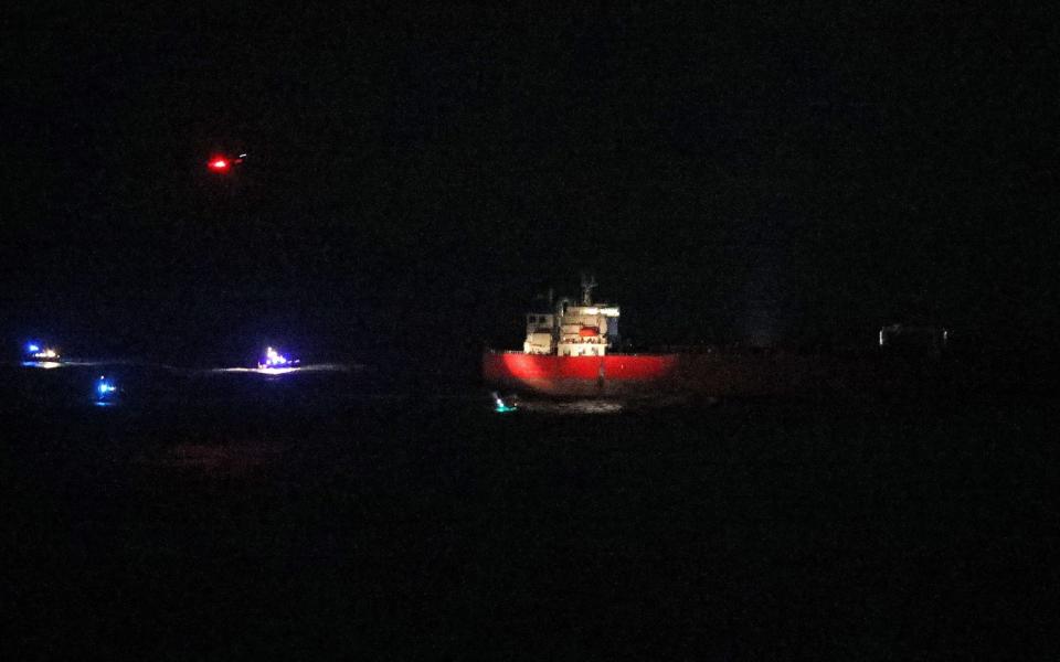 Helicopters hover overhead and boats surround the ship before the rescue - Steve Parsons/PA