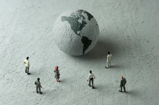 Businessman/Politician figurines examine a concrete globe (Americas) (Photo: hamzaturkkol via Getty Images)