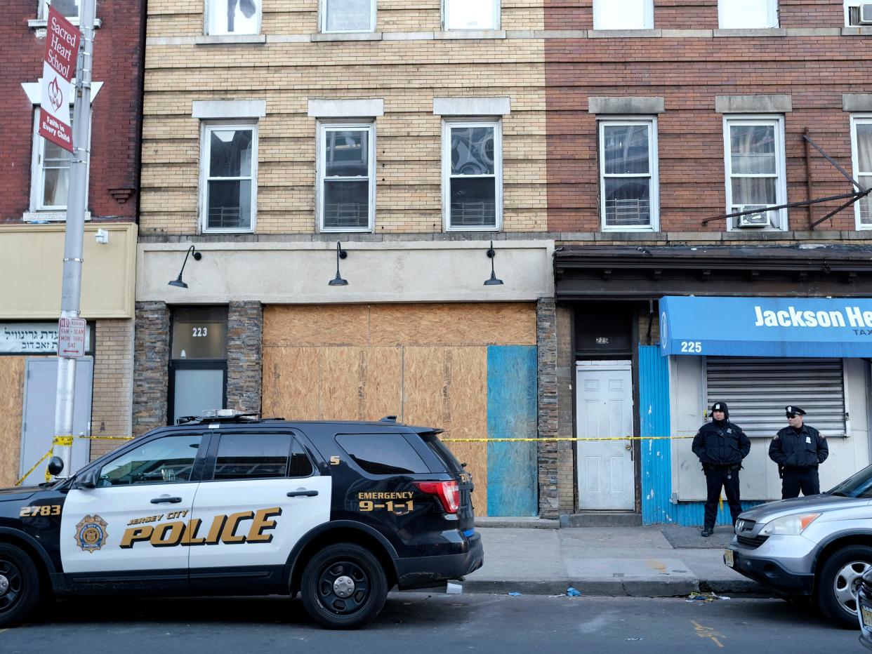 Police officers stand near the scene of a gun fight at a kosher supermarket in Jersey City, N.J., Thursday, Dec. 12, 2019. Investigators are looking to pinpoint what prompted a deadly attack on the Jewish market in Jersey City amid fears that it was motivated by anti-Semitism, as a nearby school reopened Thursday. (AP Photo/Seth Wenig)