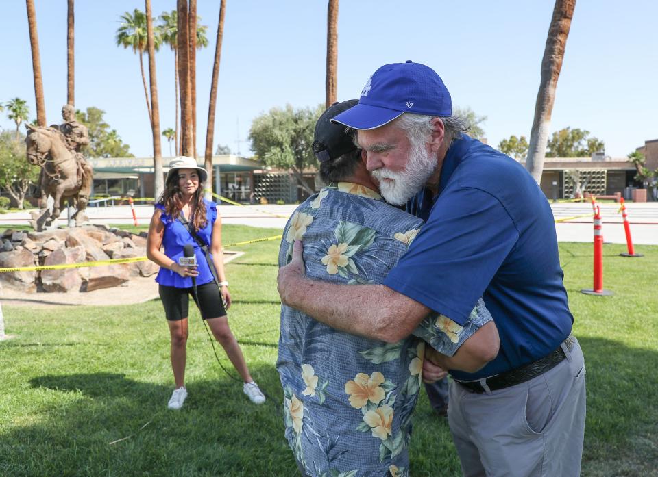 Doug Evans, right, and Amado Salinas II hug after a judge ruled the Frank Bogert statue in front of Palm Springs City Hall must not be removed at this time in Palm Springs, Calif., May 18, 2022.