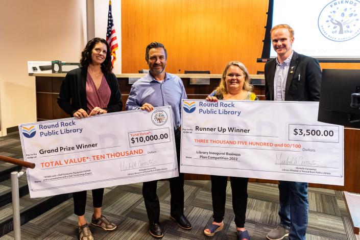 Grand prize winner Katie Kehlenbach, left, and runner-up Mandy Kelly pose with Round Rock Mayor Craig Morton, second from left, and Assistant City Manager Brooks Bennett during the final round of the Round Rock Public Library&#39;s Business Plan Competition on Tuesday at the City Council chambers.