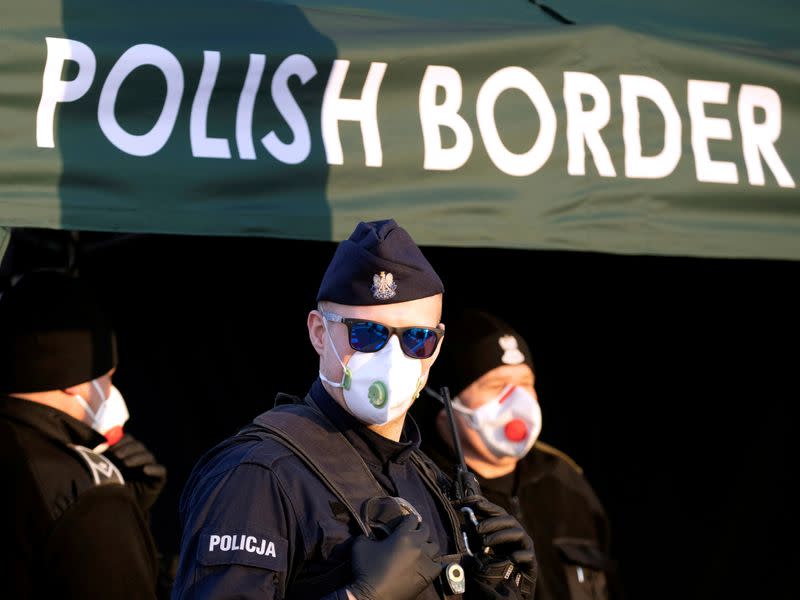 FILE PHOTO: Police officer, wearing protective mask, stands at border between Germany and Poland