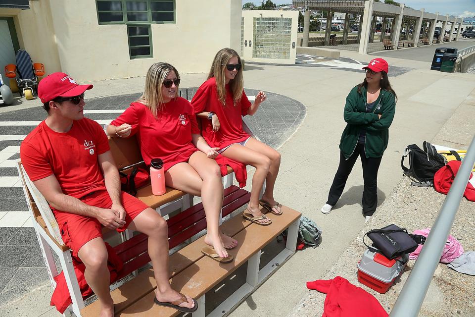 Lifeguards Joe Krivitsky, of Hull, Meghan Cormican, of Quincy, and Halle McCormack, of Scituate, chat with Hailey Chenette, of Cohasset, the supervisor of lifeguards at Nantasket Beach, while working Station 5 at Nantasket Beach in Hull on Saturday, June 11, 2022.