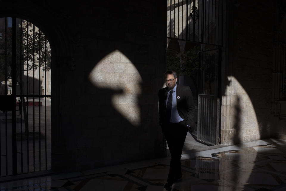 In this Thursday, Jan. 10, 2019 photo, Catalan regional president Quim Torra walks at the Palace of Generalitat or Catalan government headquarters, ahead of an interview with The Associated Press, in Barcelona, Spain. Catalonia separatist leader says that the Spanish government's bid to pass a national budget is doomed unless the wealthy northeastern region is allowed to hold a referendum on secession from the rest of the country. (AP Photo/Emilio Morenatti)