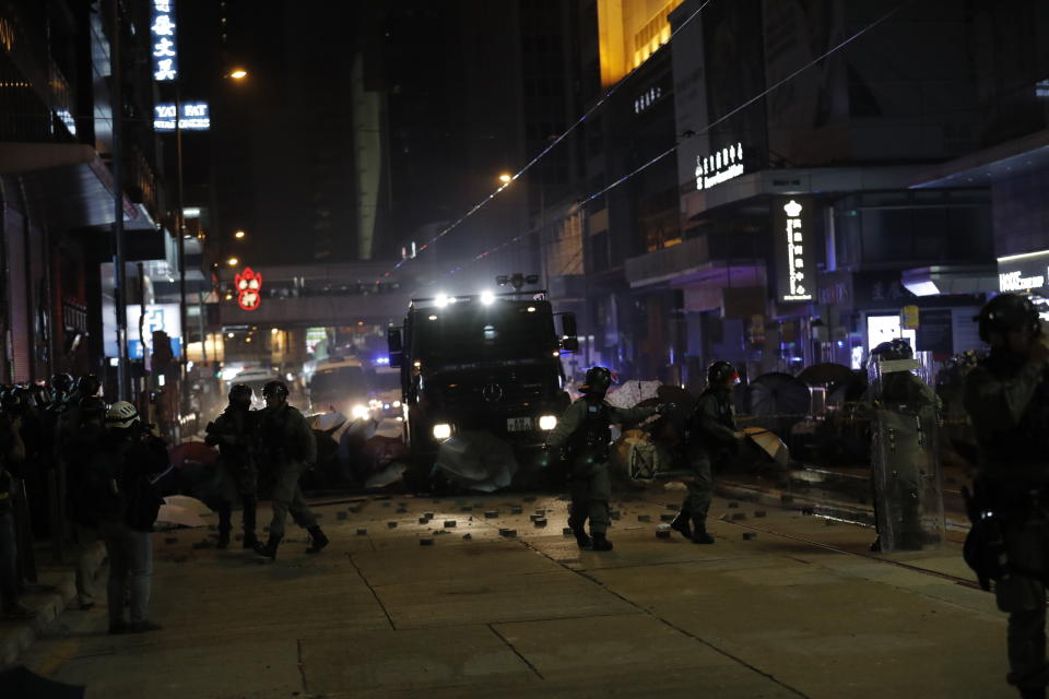 Police arrive to remove barricades set up by protestors in Hong Kong, Wednesday, Jan. 1, 2020. Hong Kong toned down its New Year’s celebrations amid the protests that began in June and which have dealt severe blows to the city’s retail, tourism and nightlife sectors. (AP Photo/Lee Jin-man)