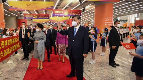 PHOTO: In this photo released by Xinhua News Agency, Chinese President Xi Jinping, center and his wife Peng Liyuan, center left, wave to welcoming crowd as they arrive to a train station in Hong Kong, Thursday, June 30, 2022. (Xie Huanchi/Xinhua via AP)