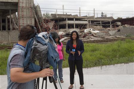 A television crew works in front of the building that collapsed in the South African town of Tongaat, about 45 km (28 miles) north of Durban, November 20, 2013. REUTERS/Rogan Ward