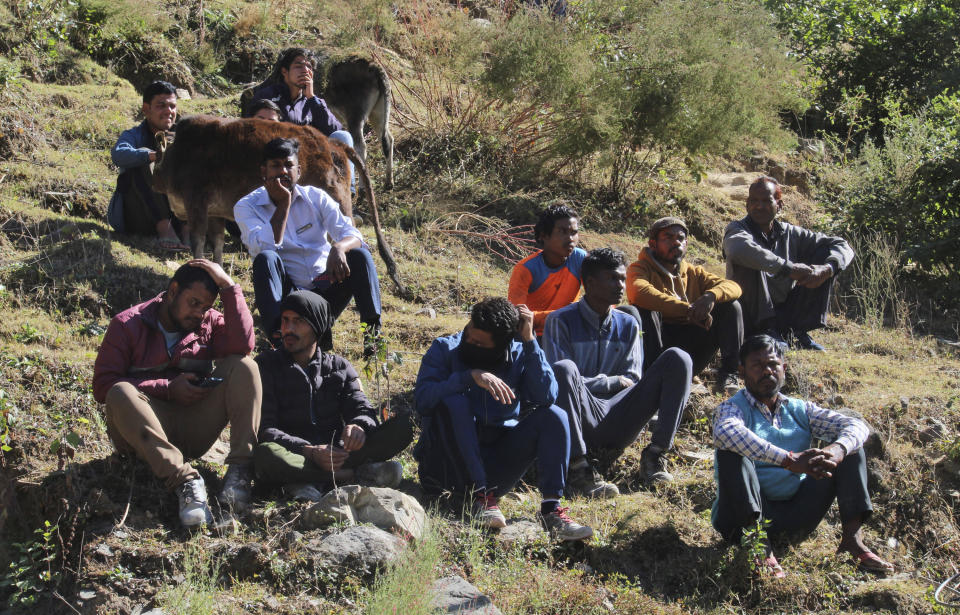 People watch rescue work at the site of an under-construction road tunnel that collapsed in mountainous Uttarakhand state, India, Saturday, Nov. 18, 2023. Forty workers were trapped in the collapsed road tunnel in northern India for a seventh day Saturday as rescuers waited for a new machine to drill through the rubble so they could crawl to their freedom. (AP Photo)