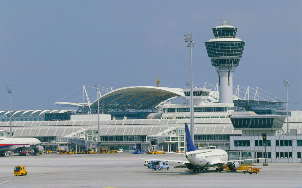 An air traffic control tower seen from a plane on the runway.