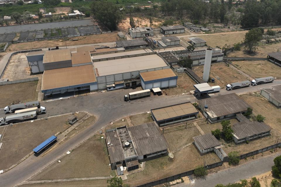 Vehicles sit outside a JBS meat processing facility In Cuiaba, Mato Grosso state, Brazil, Saturday, Nov. 18, 2023. Some lawmakers and environmental groups are opposed to JBS being listed on the New York Stock Exchange, arguing that expanded capital would allow the company, responsible for much deforestation in the Amazon rainforest, to do even more harm. (AP Photo/Andre Penner)