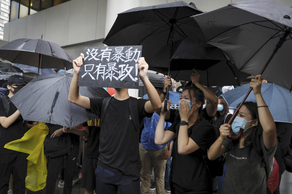 A protester holds a placard that reads: "No thug, only tyranny" whiel chanting slogans as they gather outside the Eastern Court in Hong Kong, Wednesday, July 31, 2019. Supporters rallied outside a court in Hong Kong on Wednesday ahead of a court appearance by more than 40 fellow protesters who have been charged with rioting. (AP Photo/Vincent Yu)