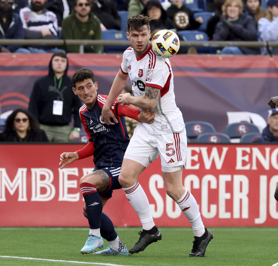 Toronto FC defender Kevin Long, right, defends the ball from New England Revolution forward Tomas Chancalay, left, in the second half of an MLS soccer match, Sunday, March 3, 2024, in Foxborough, Mass. (AP Photo/Mark Stockwell)