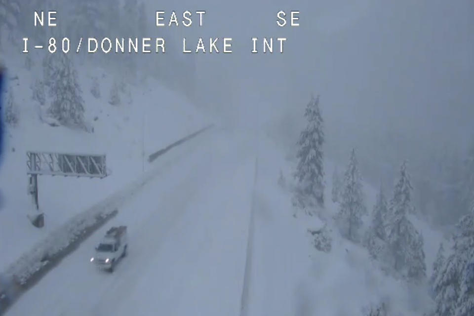 In this image taken from video from a Caltrans remote video traffic camera, a truck makes its way through the snow along Interstate 80 near Donner Lake, Calif., on Monday, Dec. 13, 2021. A major winter storm hitting Northern California is expected to intensify and bring travel headaches and a threat of localized flooding after an abnormally warm fall in the U.S. West. Light rain and snow that started falling over the weekend was heavier early Monday. (Caltrans via AP)