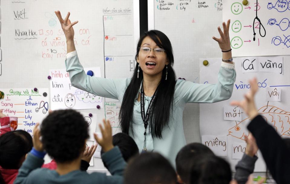 In this photo taken Friday, Feb. 14, 2014, kindergarten teacher Thao Tran teachers kindergartners in a dual immersion language class at White Center Heights Elementary School in Seattle. In a handful of schools across the country, kindergartners aren’t being taught just in English, but also in Vietnamese. The move to add Vietnamese to the growing list of languages featured in dual immersion education classes comes as the American born children of Vietnamese immigrants are striving to preserve their family’s heritage for the next generation. (AP Photo/Elaine Thompson)