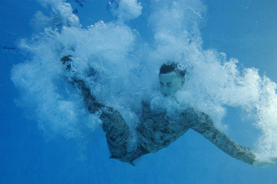 A Marine with Combat Logistics Battalion 2, dives underwater to perform a self-rescue drill during a swim qualification course at Camp Lejeune, North Carolina, March 18, 2015. 