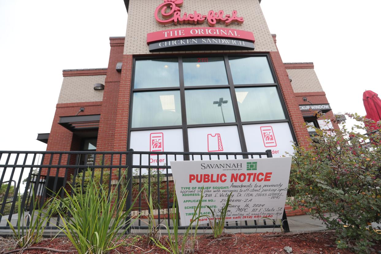 A sign is displayed outside of Chick-fil-A on Victory Drive for the MPC meeting where a variance will be discussed regarding the drive thru and parking.