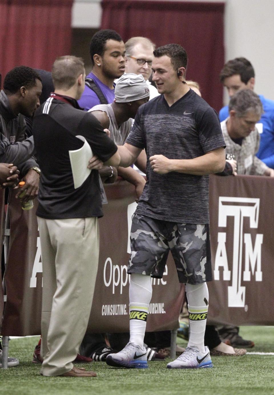 Texas A&M quarterback Johnny Manziel walks into the McFerrin Athletic Center for pro day for NFL football representatives in College Station, Texas, Thursday, March 27, 2014. (AP Photo/Patric Schneider)