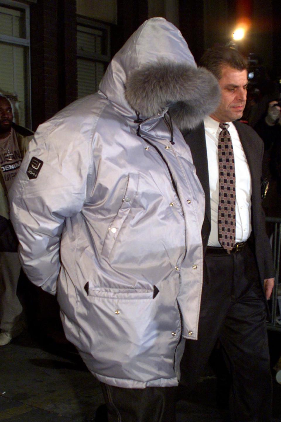 Rap musician Sean "P.Diddy" Combs (L) is led in handcuffs from the Manhattan South Police precinct in New York City December 27, 1999 by an unidentified New York City Police detective. Parading suspects in front of the media has been standard operating procedure among U.S. law enforcement agents for years. But when IMF Chief Dominique Strauss-Kahn was pictured, sweaty and exhausted-looking late Sunday night outside the New York Police Department's Special Victims Unit, some denounced the practice as downright undemocratic.  Former French Justice Minister Elisabeth Guigou called the pre-trial publicity "absolutely sickening."  And another former French justice minister, Robert Badinter, said the IMF chief had been subjected to "death by media."   REUTERS/Mike Segar/Files   (UNITED STATES - Tags: ENTERTAINMENT CRIME LAW) - GM1E75J0CIO01