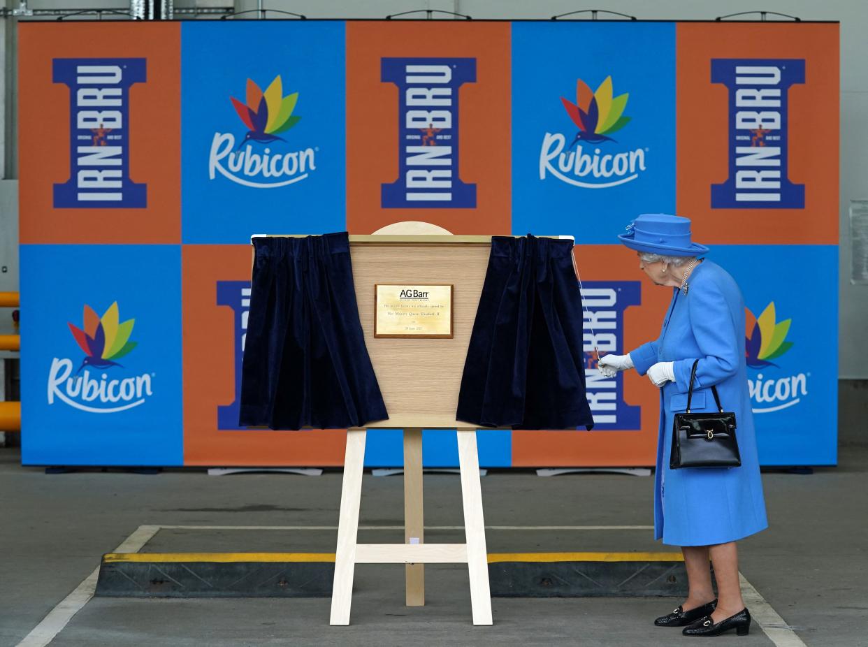 Britain's Queen Elizabeth II unveils a plaque during a visit to AG Barr's factory in Cumbernauld, east of Glasgow, where the Irn-Bru drink is manufactured on June 28, 2021. - The Queen is in Scotland for Royal Week where she will be undertaking a range of engagements celebrating community, innovation and history. (Photo by Andrew Milligan / POOL / AFP) (Photo by ANDREW MILLIGAN/POOL/AFP via Getty Images)