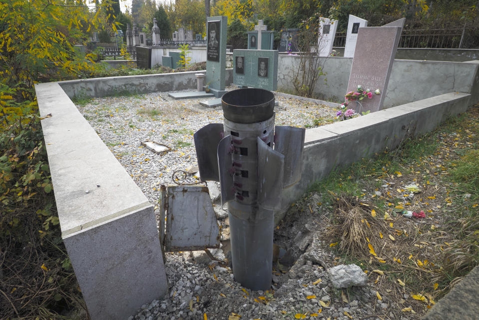 A tail of a multiple rocket 'Smerch' sticks out in a tomb at a cemetery, after shelling by Azerbaijan's artillery in Stepanakert, the separatist region of Nagorno-Karabakh, Tuesday, Nov. 3, 2020. Fighting over the separatist territory of Nagorno-Karabakh entered sixth week on Sunday, with Armenian and Azerbaijani forces blaming each other for new attacks. (AP Photo)