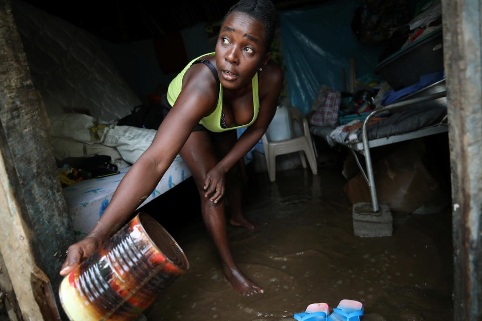 A woman uses a can to take water out of her house in a flooded area after hurricane Irma in Fort Liberte, Haiti&nbsp;