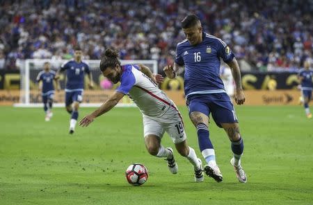 Jun 21, 2016; Houston, TX, USA; United States midfielder Graham Zusi (19) trips as Argentina defender Marcos Rojo (16) defends during the second half in the semifinals of the 2016 Copa America Centenario soccer tournament at NRG Stadium. Argentina won 4-0. Troy Taormina-USA TODAY Sports