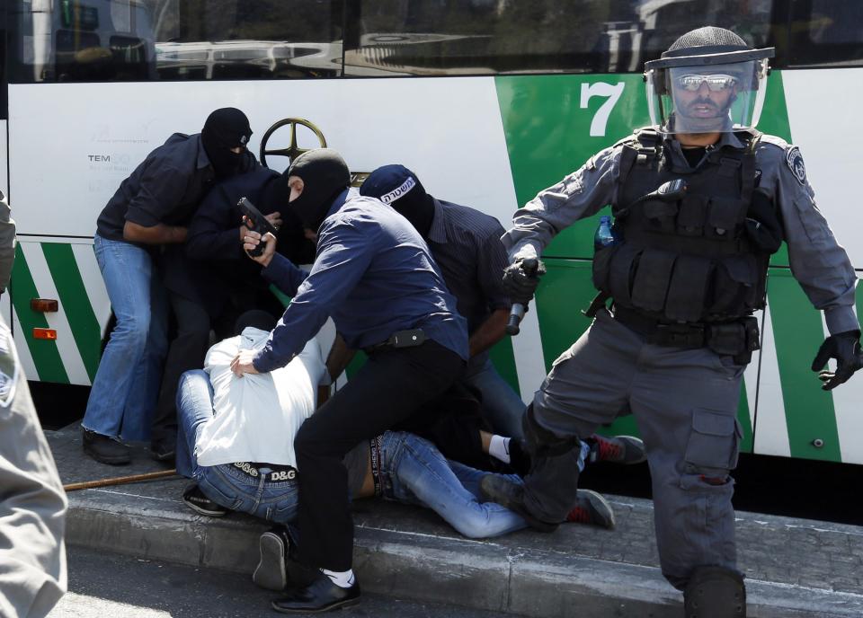 Undercover Israeli policemen detain Palestinians during clashes following Friday prayers near Jerusalem's Old City