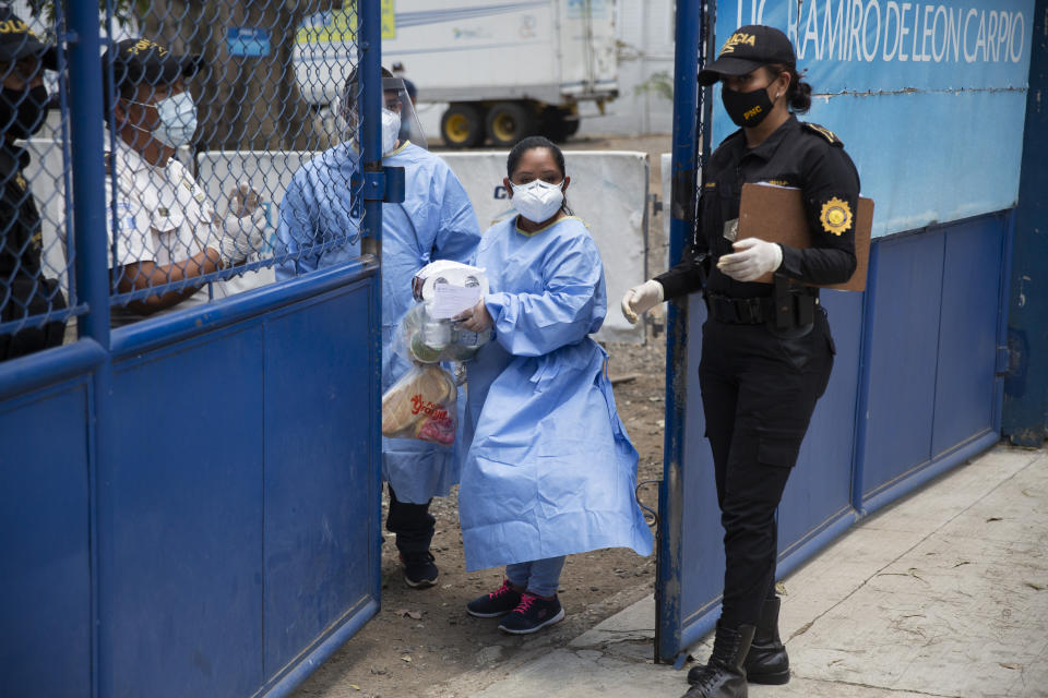 Health workers bring in supplies delivered by family members to a temporary shelter for Guatemalan citizens deported from the United States where deportees must wait for their new coronavirus test results, in Guatemala City, Thursday, April 16, 2020. Guatemala's health minister said on Tuesday that deportees from the U.S. were driving up the country's COVID-19 caseload. (AP Photo/Moises Castillo)