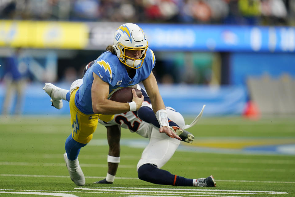 Los Angeles Chargers quarterback Justin Herbert (10) is tackled by Denver Broncos cornerback Nate Hairston (27) during the first half of an NFL football game Sunday, Jan. 2, 2022, in Inglewood, Calif. (AP Photo/Ashley Landis)