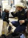 CeJay Jones, 6, practices holding on with his father Chris (R) looking on before he competed in the mini bull riding competition at the 108th National Western Stock Show in Denver January 11, 2014. The show, which features more than 15,000 head of livestock, opened on Saturday and runs through January 26. REUTERS/Rick Wilking (UNITED STATES - Tags: ANIMALS SOCIETY)