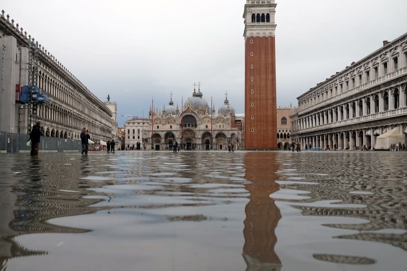 Tourists walk in St. Mark’s Square after days of severe flooding in Venice