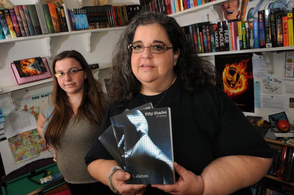 In a photo from 2012, Linda Tyndall (right) and her daughter Rebecca are pictured with copies of  "50 Shades of Grey" at their home in Viera. The two fought to get the book back on Brevard County library shelves after it was removed.