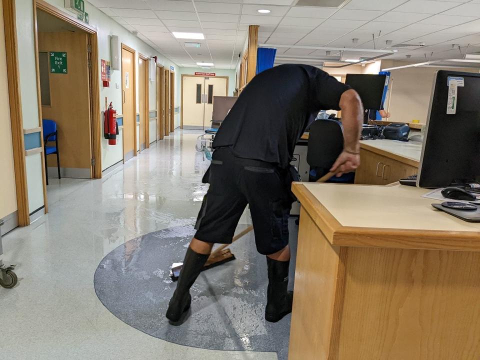 Hospital worker sweeps flooddwater from the building (Bassetlaw Hospital)